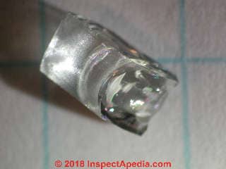Microscopic examination of a fragment of shattered oven door glass from a broken Jenn Air oven door (C) Daniel Friedman at InspectApedia.com