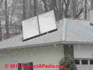 Snow-coatged solar hot water heating panels on a Poughkeepsie NY rooftop (C) 2013 Daniel Friedman