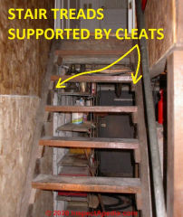 Basement stair treads supported by 2x3 cleats adequately fastened to stringers, not split (C) Daniel Friedman at InspectApedia.com