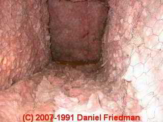 Photo of air ducts improperly lined with fiberglass batt insulation and chickenwire  (C) InspectApedia.com  