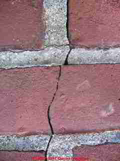 Photograph of a brick chimney cracked exterior, possibly due to heat.
