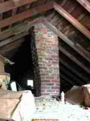 Photograph of a corbelled brick chimney, from the attic.
