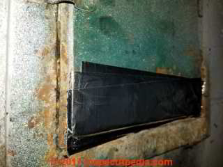 Metal tape repair on rust-damaged chimney cleanout door (C) Daniel Friedman