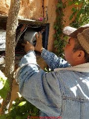 Pulling off an electric meter, San Miguel de Allende CFE employee (C) Daniel Friedman at InspectApedia.com