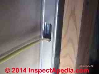 Unprotected NMC wiring passing through a metal stud violates electrical code (C) InspectApedia Bob Sisson