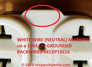 White or neutral terminal marking ona 1963 vintage un-grounded back-wire-only electrical receptacle (C) Daniel Friedman at Inspectapedia.com