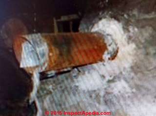 Chrysotile asbestos in cement used to seal flue to chimney (C) InspectAPedia PH