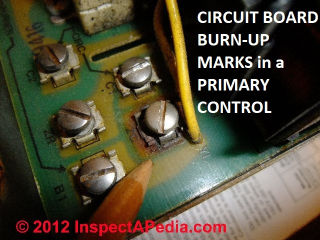 Overheating marks on the circuit board show that this pirmary control has been damaged beyond repair (C) Daniel Friedman at InspectApedia.com