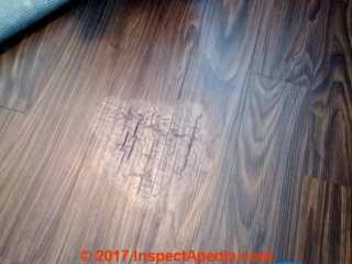 Water or solvent-damaged laminate flooring (C) InspectApedia.com  SM