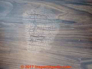 Water or solvent-damaged laminate flooring (C) InspectApedia.com  SM