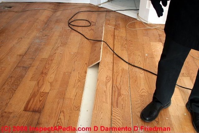 The laminate wood flooring shown at left was buckled and destroyed by 