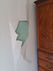 Peeling failing surface of Magnesium Oxide wallboard in the UK (C) InspectApedia.com BuildingAdvisor.com 