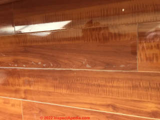 Peeling on high gloss laminate flooring (C) InspectApedia.com Suzie