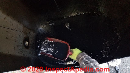 Removing decades of sludge from the interior of an above-ground oil storage tank during tank replacement (C) Daniel Friedman at InspectApedia.com