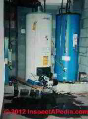 Puddles on the floor start the diagnosis of cause of a water heater leak (C) Daniel Friedman InspectApedia.com