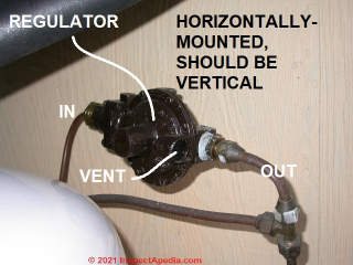 LP gas regulator in poor position: horizontal, exposing its vent to water entry or ice (C) Daniel Friedman at InspectApedia.com