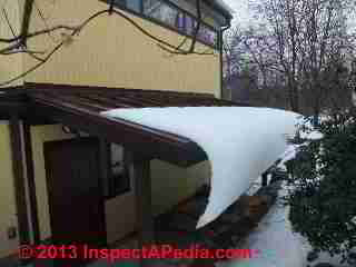 Snow curls around and hangs down from a standing seam metal roof that has no snow guards - Poughkeepsie (C) 2013 Daniel Friedman