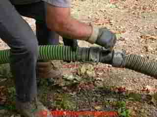 PHOTO of the operator connecting sections of septic tank cleanout vacuum hose.