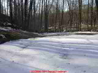 PHOTO of melting snow and depressions indicating septic drain field trench locations.