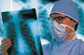 Image of a physician examining a lung x-ray, photo source: OSHA US Department of Labor