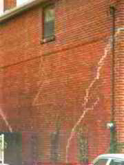 Photograph of structural damage to a brick wall