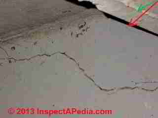 Concrete floor settlement visible at wall © Daniel Friedman at InspectApedia.com
