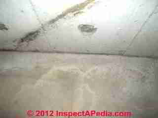 Photograph of contraditory diagonal "cracks" in a poured concrete foundation wall (C) InspectAPedia & C.C. 