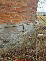 Frost heave / settlement cracks in a complex masonry foundation wall using stone, concrete, and brick (C) InspectApedia.com reader contribution