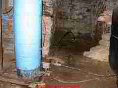 Photograph of  a well less than 10 ft from a house foundation - this may be fine until there is a need to treat the building for termites. A well too close to the building precludes some pesticide applications out of
concern for contaminating the well.