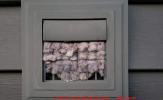 Fiberglass-clogged dryer vent screen is a fire hazard and suggests other building issues (C) InspectApedia.com John Cranor