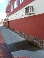 AC Condensate drainage spilling onto and across a sidewalk (C) Daniel Friedman at InspectApedia.com