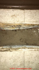 Metal duct register rusted away to expose dirt below floor slab (C) InspectApedia.com