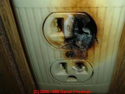Photograph of an overheating aluminum-wired electrical outlet - thanks to J Simmons.
