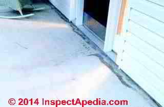 Dark stains along concrete slab exterior porch perimeter (C) InspectAPedia Rhonda