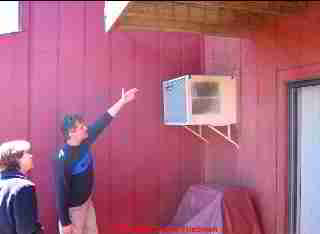 Photograph of a contractor pointing out wall leaks at an air conditioner..