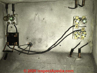 Asbestos paper or fabric used to line fuse panel (C) InspectApedia.com Sharon