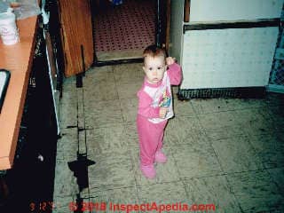 Toddler on a kitchen floor with asbestos-suspect tiles in poor condition (C) InspectApedia.com reader contribution