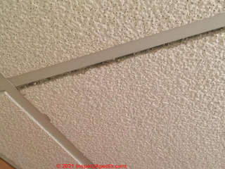 Suspended ceililng tile, gray core, unknown material, could contain asbestos, undamaged (C) InspectApedia.com doug