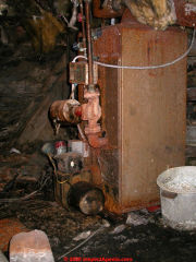 Rusty, leaky, old and inefficient boiler in a wet crawl space gets far too little service (C) Daniel Friedman at InspectApedia.com