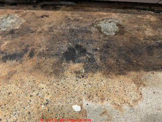 Black-brown stains on concrete floor (C) InspectApedia.com Noah