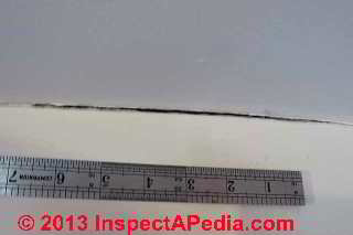 Drywall crack at intersection typical of ceiling wall separation from arching roof truss © Daniel Friedman