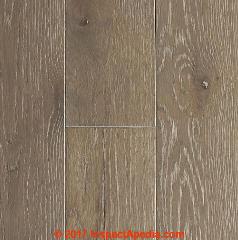 Damaged engineered hardwood floor needing repair - (C) InspectApedia.com Rawzlynd Brown
