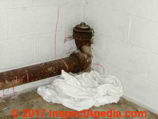 Cast iron plumbing trap at the building's main drain exit point or house trap (C) Daniel Friedman InspectApedia.com