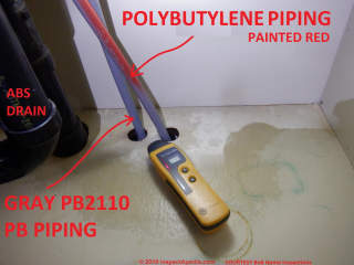 Plastic water pipes: Gray PB Polytbutylene (leak prone) pipes and p;robably red PEX piping in a home (C) InspectApedia.com BnB Home Inspections