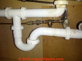 Leak stains on plastic kitchen sink drain trap and drain piping (C) InspectApedia.com Daniel Friedman