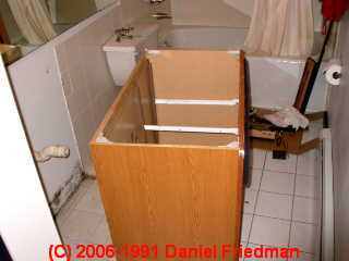 Photograph of inspecting below a bath vanity for hidden mold.