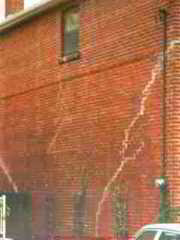 Photograph of structural damage to a brick wall