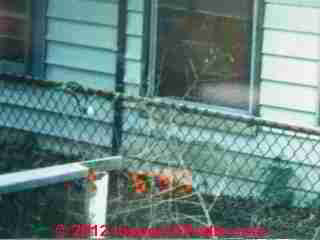 Buckled siding at ground level indicates sill crushing © Daniel Friedman at InspectApedia.com