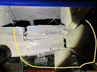 Wood beam joint over bent  metal plate atop metal post (C) Inspectapedia.com Anonymous