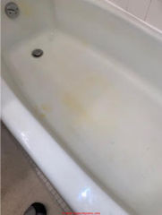 Yellow stains on plumbing fixtures due to water contaminants (C) InspectApedia.com JH